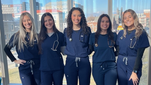 Nurses in scrubs pose for photo