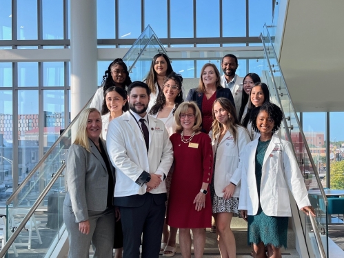 Students pose on stairs with staff